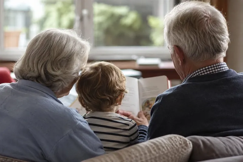 Grands-parents lisant une histoire à leur petit-enfant - Proxydomi